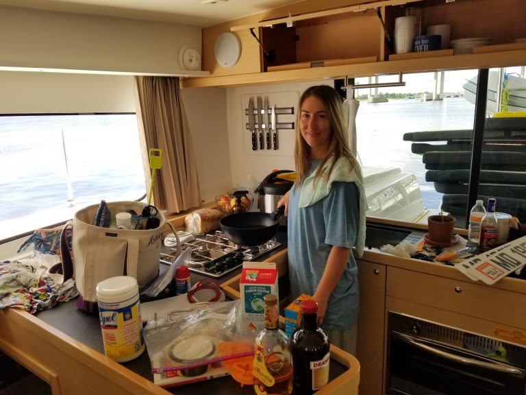 Ashley cooking breakfast in the cluttered galley