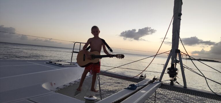 Isaiah playing his guitar at sunset